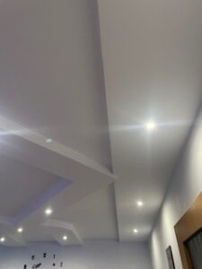 Geometrisch gestaltete Trockenbaudecke mit eingelassenen LED-Spots, abgestufter Struktur und heller Ausleuchtung